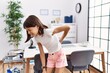 © Krakenimages.com - Young hispanic girl standing at pediatrician clinic suffering of backache, touching back with hand, muscular pain
