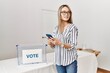 © Krakenimages.com - Young chinese woman using smartphone voting at electoral college