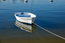 empty rowboat moored in the harbor on a sunny morning