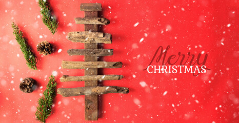 Wall Mural - Wood stick rustic Christmas tree on red background for happy holiday greeting.