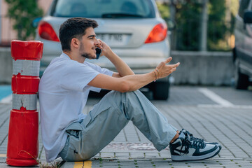 Canvas Print - teenager in the street sitting with mobile phone or smartphone