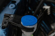 © Roman - Windshield washer fluid reservoir cap. Windshield washer liquid cap inside a car engine. Closeup cap windshield cleaner water liquid tank.