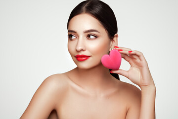 Wall Mural - young beautiful woman with heart-shaped gift. girl with pure perfect face skin. cosmetology, beauty 