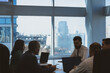 © xartproduction - Silhouettes of people sitting at the table. A team of young businessmen working and communicating together in an office. Corporate businessteam and manager in a meeting