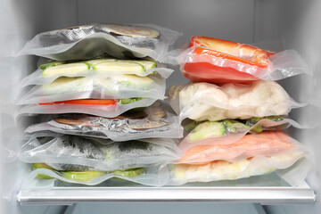 Vacuum bags with different products in fridge. Food storage