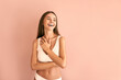  Attractive young woman in white basic underwear laughing on pink background.