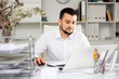 © JackF - Caucasian man office manager sitting at table and using laptop computer.