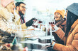 © Nicolas Micolani - Young people toasting red wine at restaurant pub - Happy friends having fun together at winery bar wearing winter clothes - Dining lifestyle and friendship  concept - Focus on  central glass