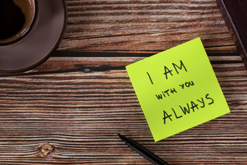 I AM with you always, handwritten biblical verse on note with holy bible book and cup of coffee on wooden background. Top table view. Hope, comfort, and encouragement from God Jesus Christ.