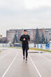 © Dusan - A young man training running stretching jumping a rope on the stadium early in the cold morning