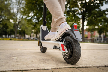 unknown man standing or driving electric kick scooter e-scooter