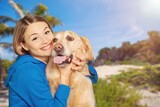 Fototapeta Zwierzęta - Happy young woman play with a dog on outdoors