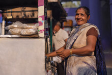 Portrait Of A Smiling Female Vendor At Her Roadside Food Stall