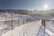 Polska zima w lesie podczas wschodu i zachodu słońca z zaśnieżonymi drzewami, krzewami, błękitem nieba i leśnymi  drużkami.