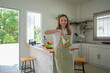 © Songsak C - Asian woman preparing salad in the kitchen at home