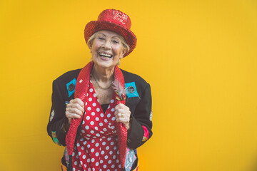 Wall Mural - Happy and funny  grandmother posing on colored backgrounds. Old woman having fun and celebrating. Concept about third age and seniority