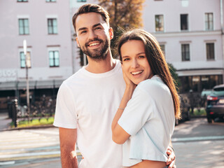 Wall Mural - Smiling beautiful woman and her handsome boyfriend. Woman in casual summer jeans clothes. Happy cheerful family. Female having fun. Sexy couple posing in the street at sunny day