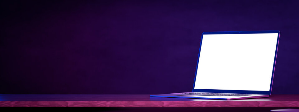 Wall Mural -  - Laptop mockup table, dark blue wall. Side view open modern laptop mockup. Laptop blank white screen mockup on wooden table. Mockup in colorful bright neon UV blue and purple lights. 3d rendering