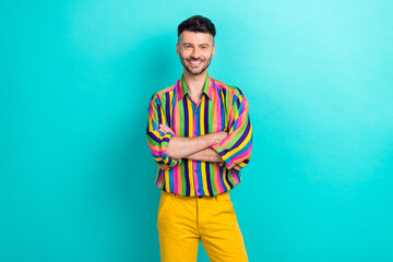 Canvas Print - Photo of cheerful handsome confident man with brunet hair dressed striped shirt arms crossed isolated on turquoise color background