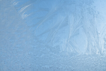 Wall Mural - snow frost in the form of natural patterns on the window pane against the background of the morning 