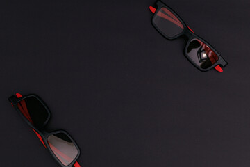 Wall Mural - Black sunglasses lying on a black background background