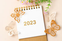 A 2023 Calendar Desk For The Organizer To Plan And Paper Butterfly With Flower On Yellow Background.