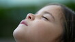 Child face looking up at sky with eyes closed pensive little girl