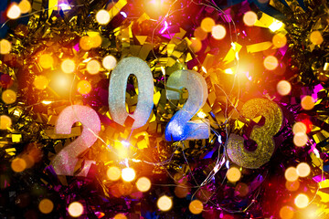 Wall Mural - happy new year's 2023 on colorful tinsel and light bokeh