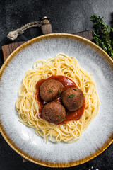 Wall Mural - Vegetarian pasta with meatless Meatballs from plant based meat and tomato sauce. Black background. Top view