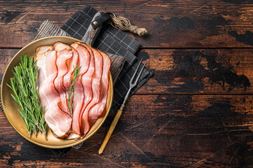 Dry cured pork Black Forest Ham bacon with rosemary. Wooden background. Top view. Copy space