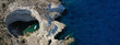 Aerial drone ultra wide panoramic photo with copy space of famous round open cave of Sykia surrounded by steep volcanic white cliffs accessible only by a small opening, Milos island, Cyclades, Greece