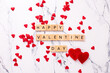 Valentines day postcard. Romantic  layout. Wooden latters  and big and little hearts on  white marble background.  Top view.