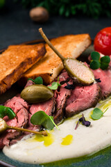 Canvas Print - Vitello tonnato, sliced tuna, capers, tomatoes, sauce, fried toast, closeup.