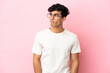 © luismolinero - Young Argentinian man isolated on pink background making doubts gesture looking side