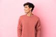 © luismolinero - Young Argentinian man isolated on pink background looking side