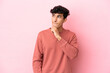 © luismolinero - Young Argentinian man isolated on pink background having doubts and thinking