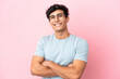 © luismolinero - Young Argentinian man isolated on pink background With glasses with happy expression
