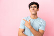 © luismolinero - Young Argentinian man isolated on pink background With glasses and pointing side
