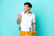 © luismolinero - Young electrician Argentinian man isolated on blue background pointing to the side to present a product