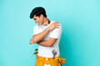 © luismolinero - Young electrician Argentinian man isolated on blue background suffering from pain in shoulder for having made an effort