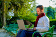 © PRASANNAPIX - Young indian man in warm wear and working on laptop at park