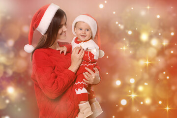 Poster - Happy mother with cute baby in Christmas outfits and Santa hats on red background, space for text. Magical festive atmosphere