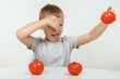 The boy don't like tomato. Nutrition and healthy eating habits for kids concept.