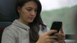 © Marco - Woman texting message while traveling by train. Passenger commuting to work or study using modern technology. Person typing on smartphone device