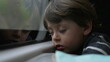 © Marco - One sleepy little boy almost falling asleep while traveling on train in motion. Portrait of passenger child by window looking at landscape