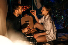 Valentines Day Home Date Ideas Save Money Budget Tips. Young Couple In Love Celebrating Valentines Day At Home. Romantic Couple In Pajamas Eating Pizza Near Fireplace
