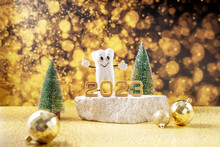  Cartoon Model Of A Tooth, The Numbers 2023 And A Tube Of Toothpaste On A Podium Made Of Stone And Christmas Trees On A Background Of Golden Bokeh