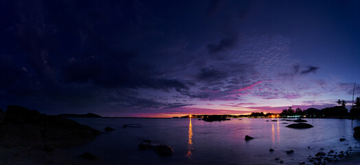 Wall Mural - Beautiful seascape with colorful sky. Sunset and night time on the rock beach.