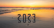 Leinwandbild Motiv Bonne année 2023 : concept de nouvelle année 2023 avec un lever de soleil sur la plage et les chiffres 2023 en reflet dans la mer.