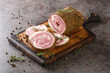 Pancetta is cured pork belly made with salt, herbs and spices closeup on the wooden board on the table. Horizontal